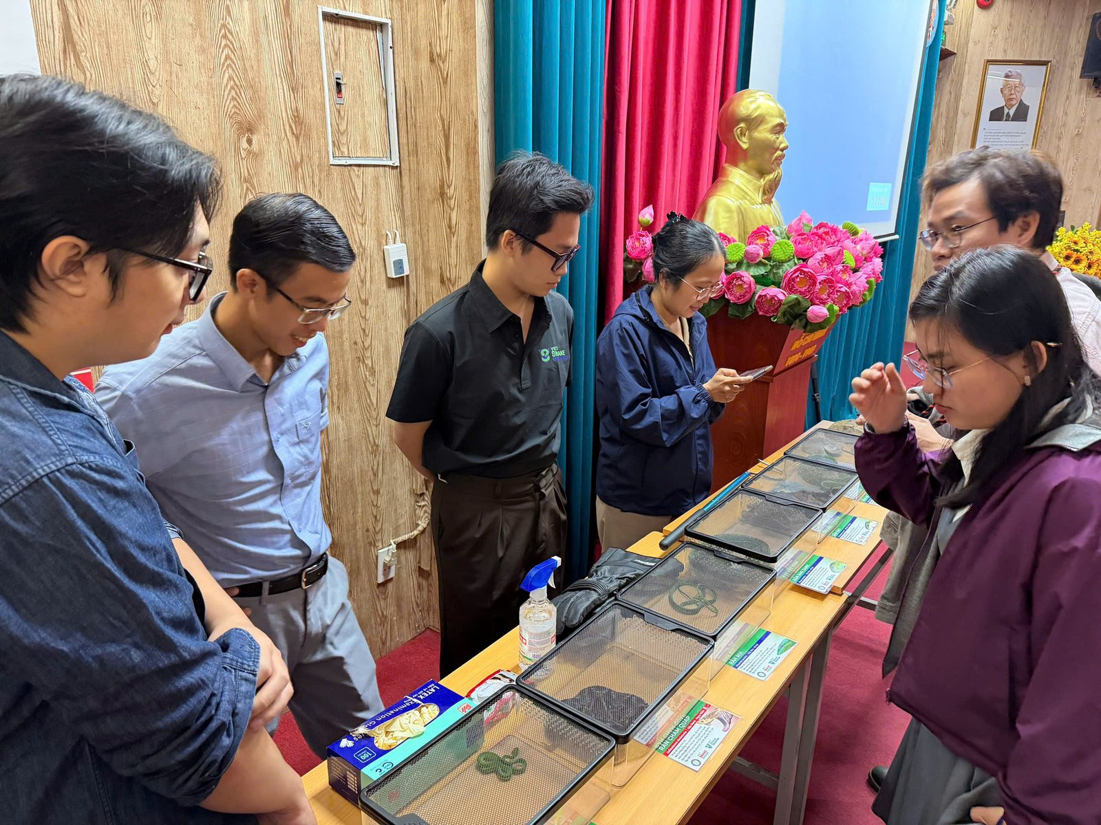 Bác sĩ và người tham dự quan sát các mẫu rắn sống tại bàn trưng bày của Viet Snake Rescuer